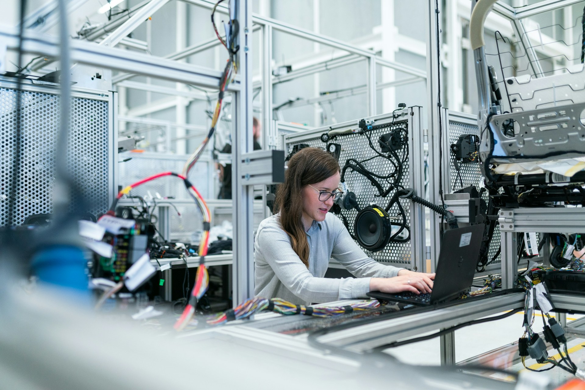 Engineer using a laptop at a high-tech electronics production line